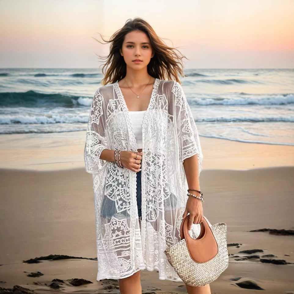 Woman in a white lace cover-up on a beach at sunset