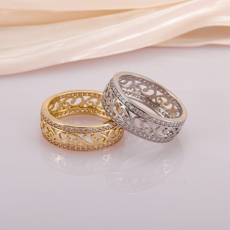 Two intricately designed rings, one gold and one silver, on a light background.