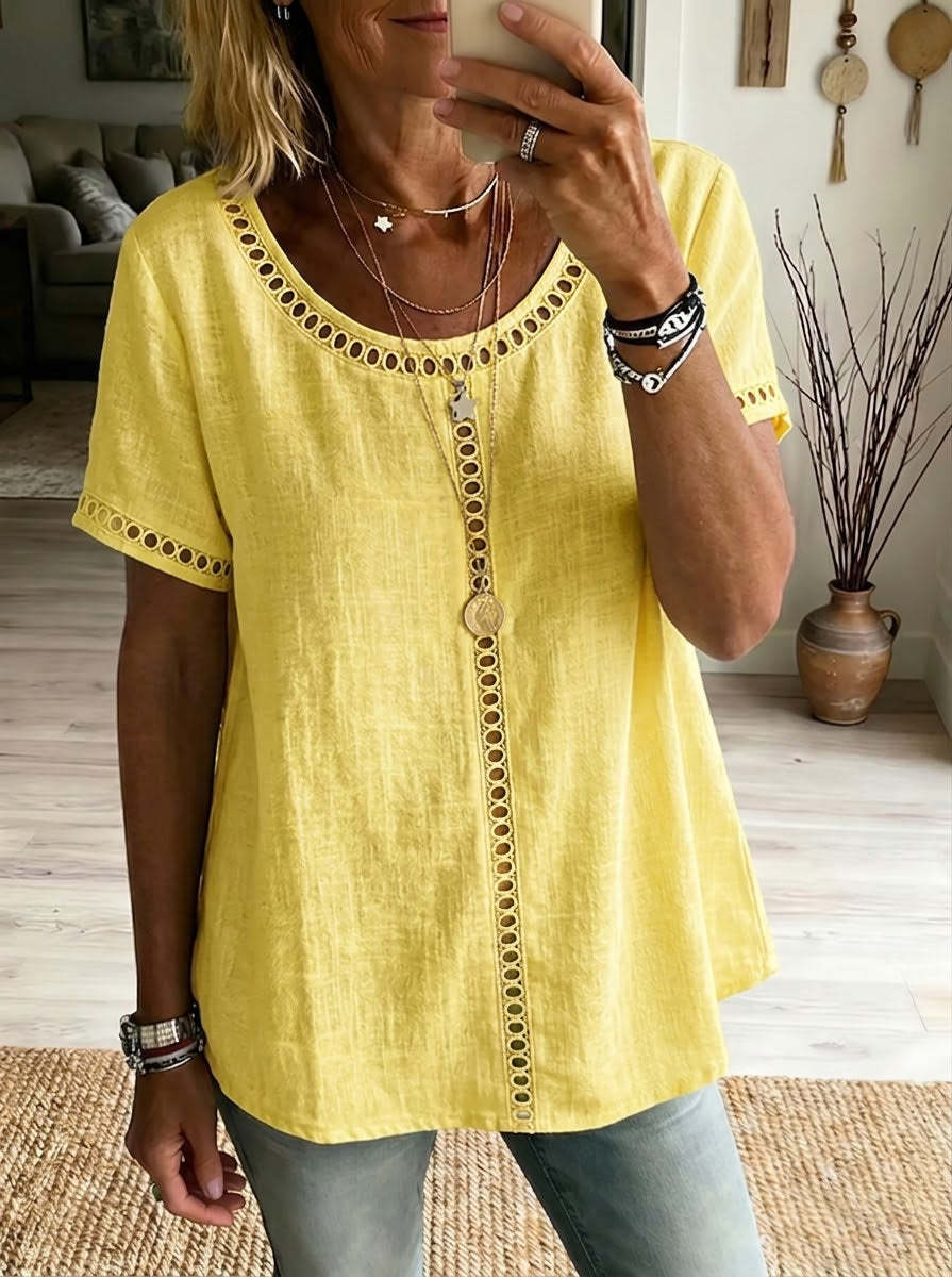 Person wearing a yellow top with decorative buttons in a home setting
