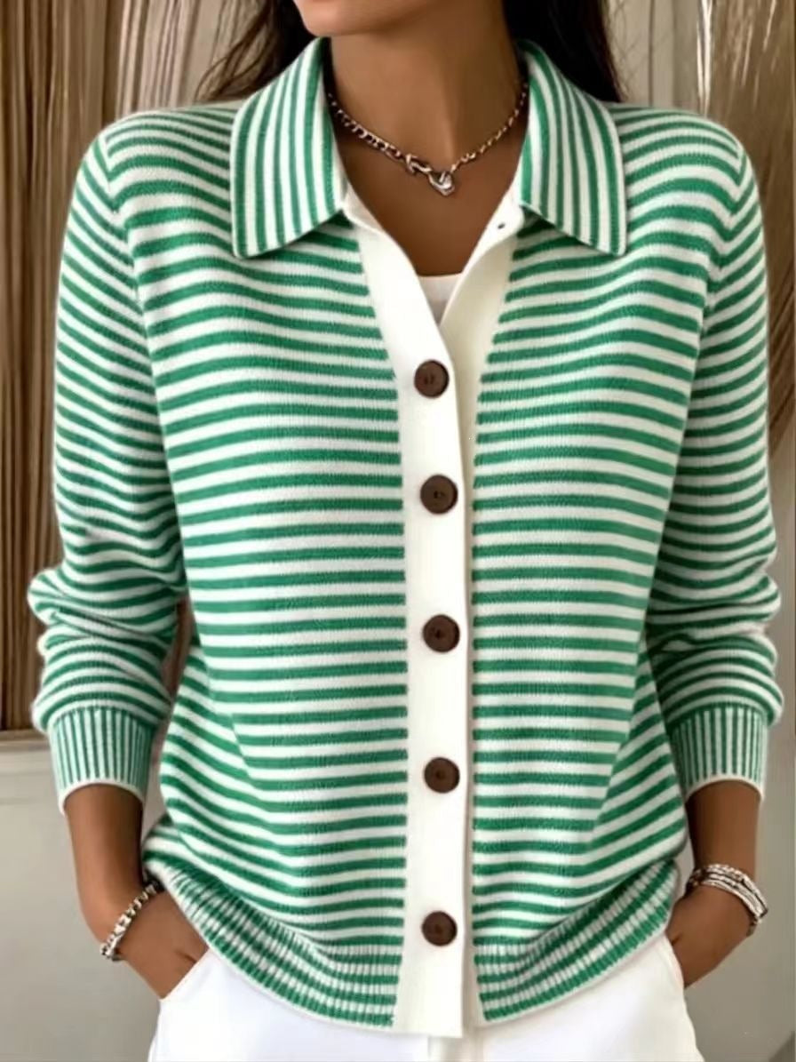 A woman wearing a green and white striped knit cardigan with a white button placket and brown buttons, layered over a white top.
