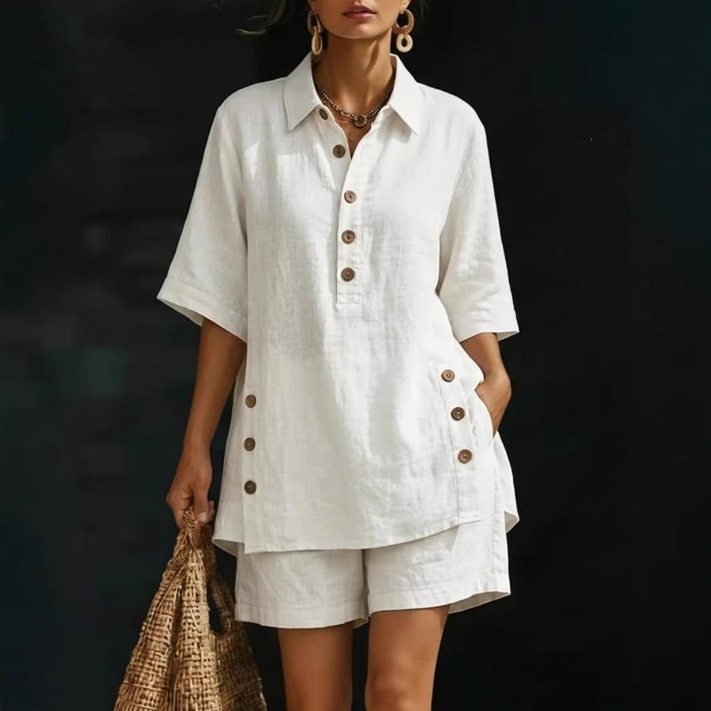 Woman wearing a white outfit with brown buttons against a dark background
