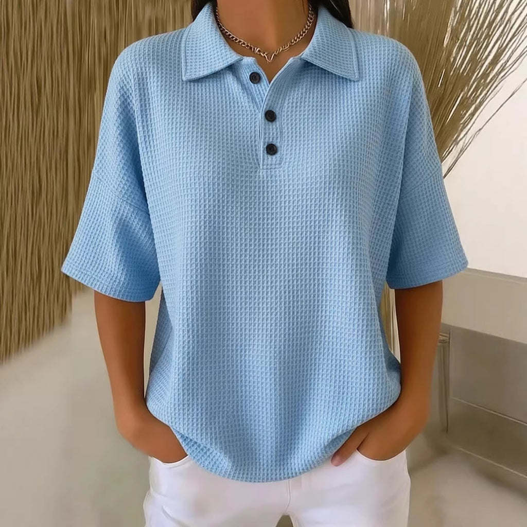 Light blue textured polo shirt worn by a mannequin against a neutral background