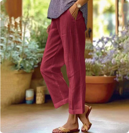 Person wearing pink pants standing in a garden with plants and flowers in the background