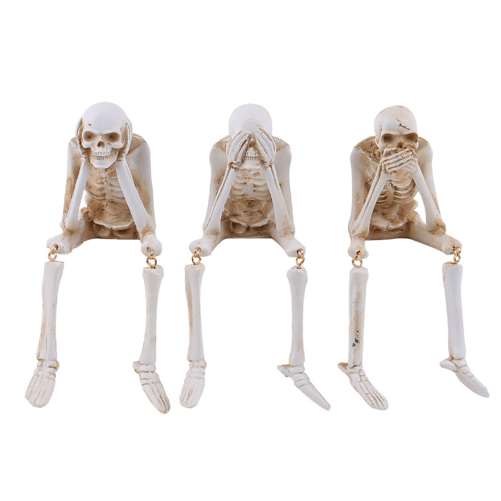 Three skeleton figures in a 'see, hear, speak no evil' pose on a white background