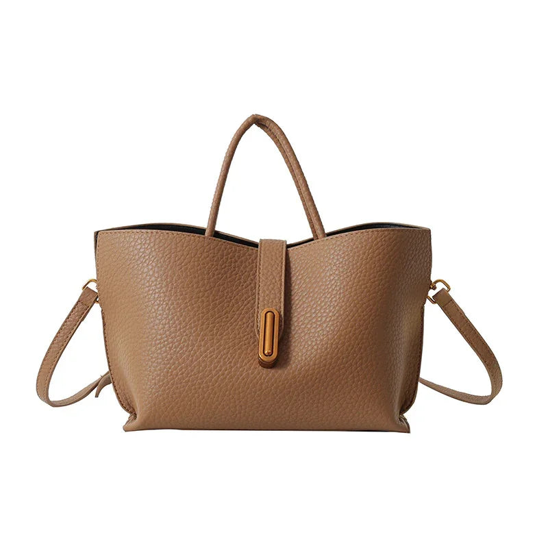 Brown leather tote bag with shoulder strap on a white background