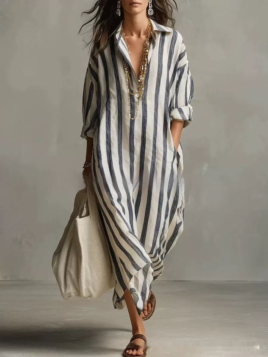 Woman wearing a long, striped dress with a plain background