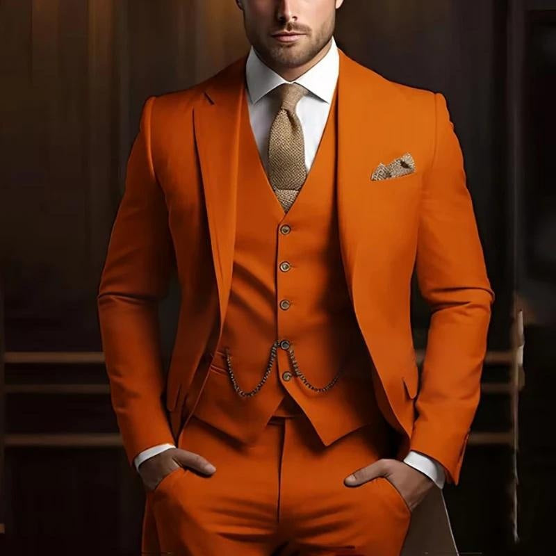 Man wearing an orange suit with a patterned tie and pocket square against a dark background
