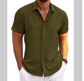Man wearing a green short-sleeve shirt and white pants on a plain background