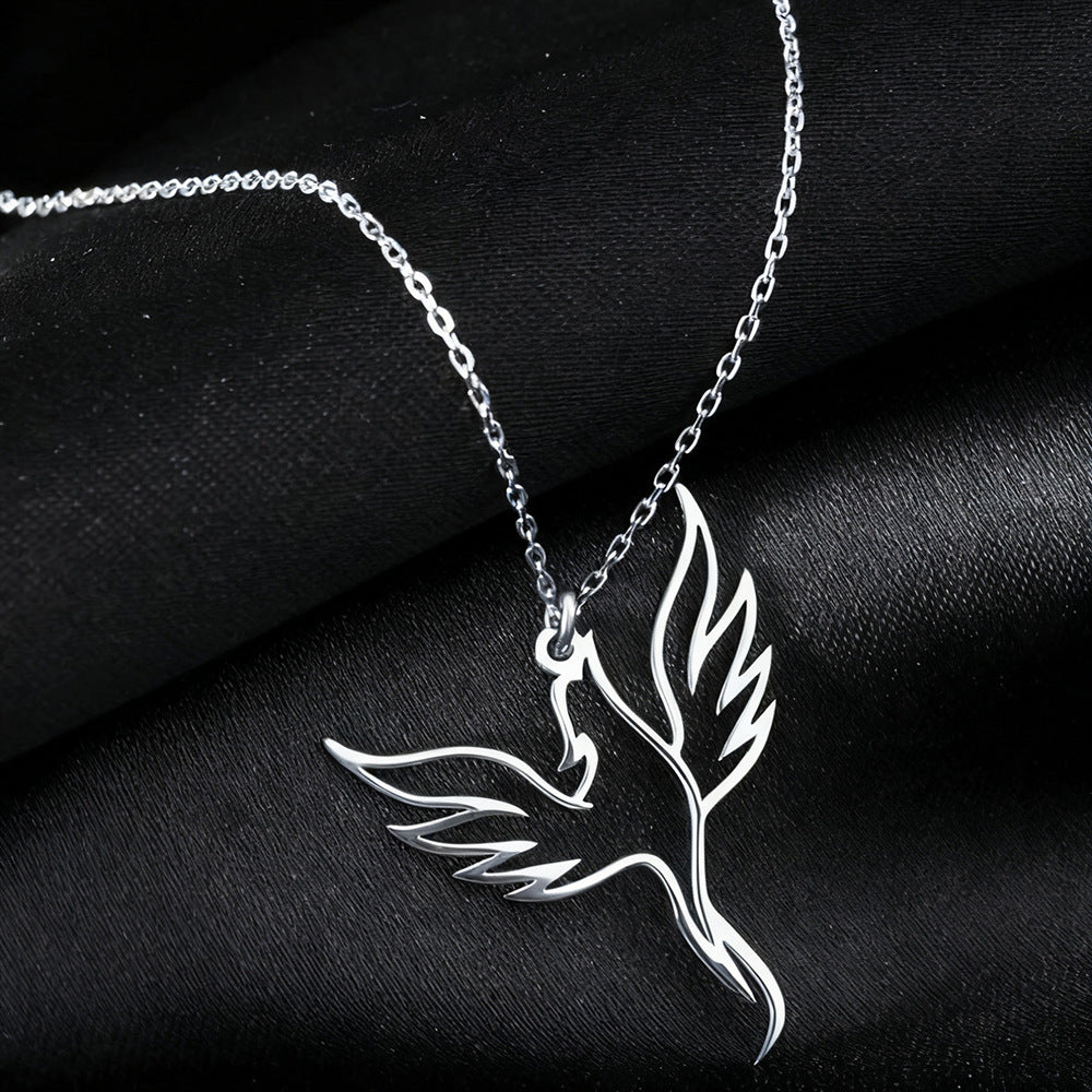 Silver phoenix necklace on a black fabric background