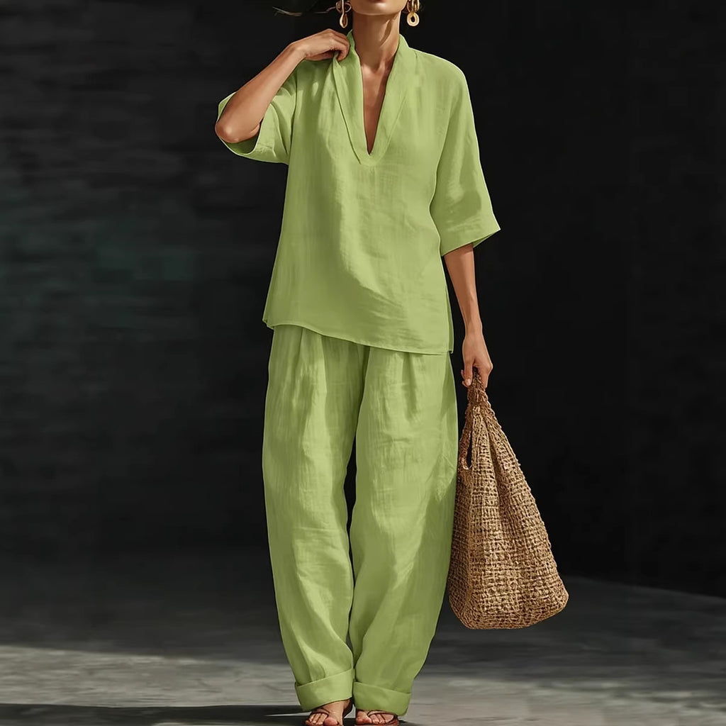 Person wearing a green outfit holding a woven bag against a dark background