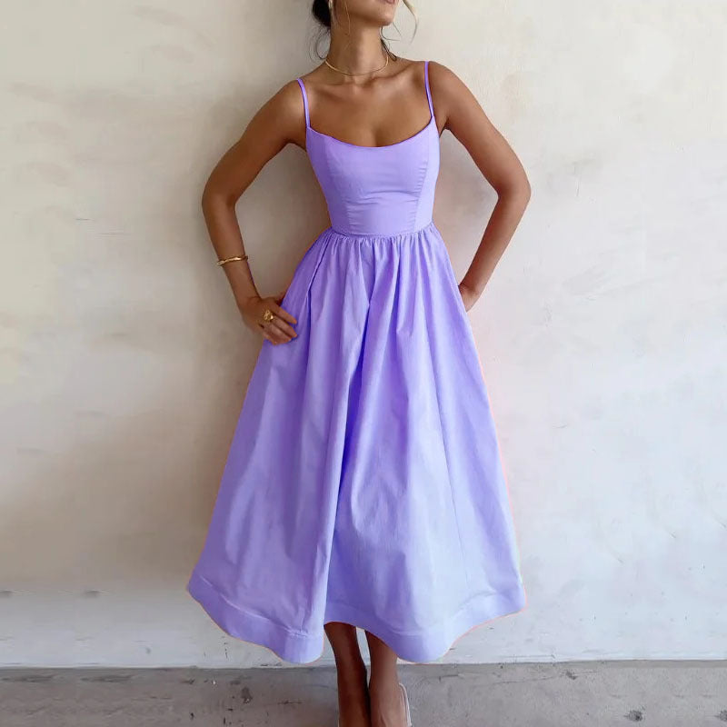 Woman wearing a purple dress against a plain background
