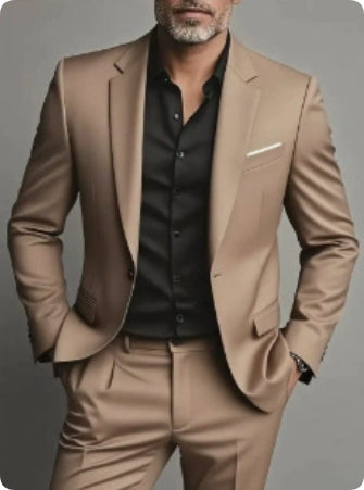 Man wearing a beige suit with a black shirt on a gray background