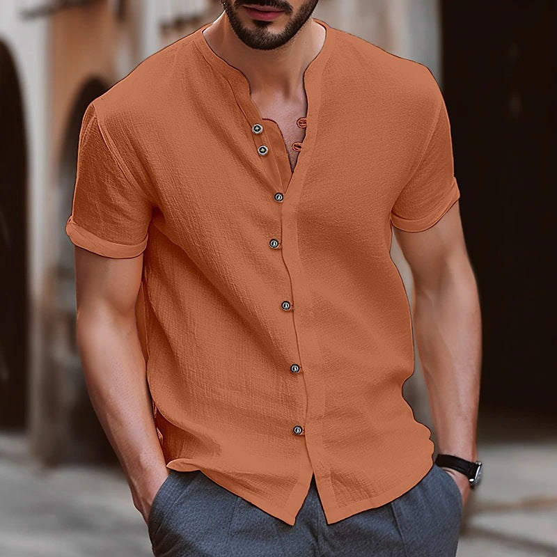 Man wearing an orange button-up shirt with a blurred background