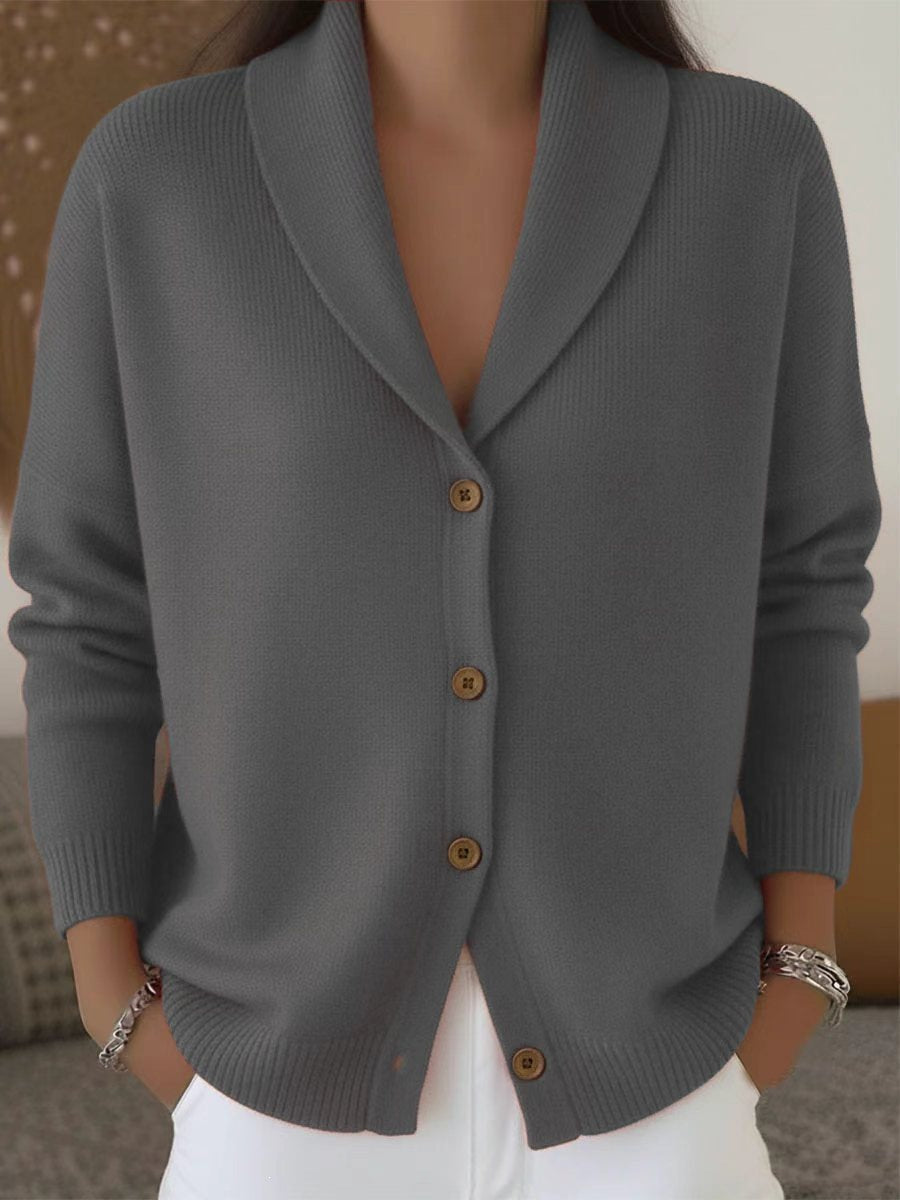 Gray cardigan with brown buttons worn by a person, against a neutral background