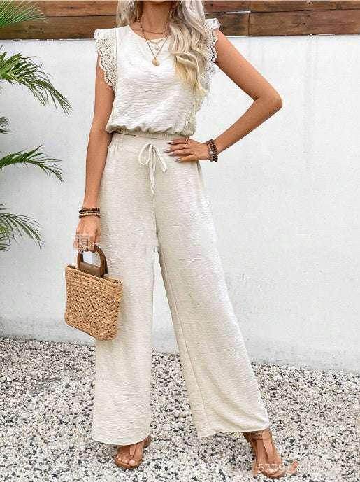 Woman in stylish cream jumpsuit with lace sleeves, holding straw bag, ZA-Zola fashion