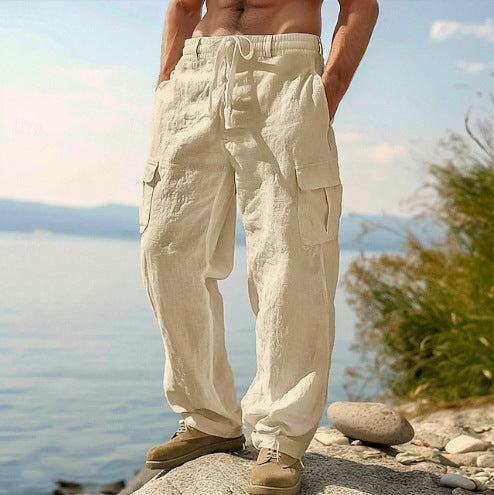Person wearing beige cargo pants standing on a rock by a body of water with a scenic background.