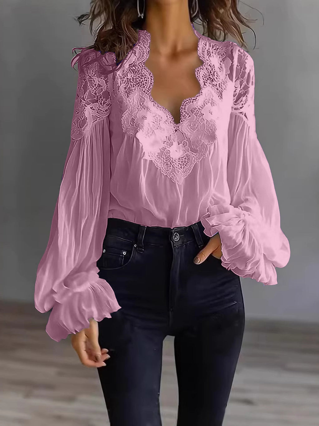 Pink lace blouse with long sleeves worn by a person against a neutral background
