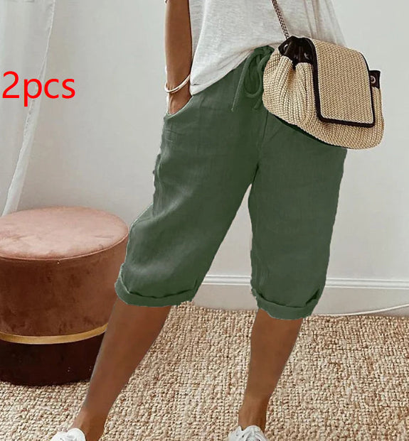 Person wearing green shorts and a straw bag indoors.