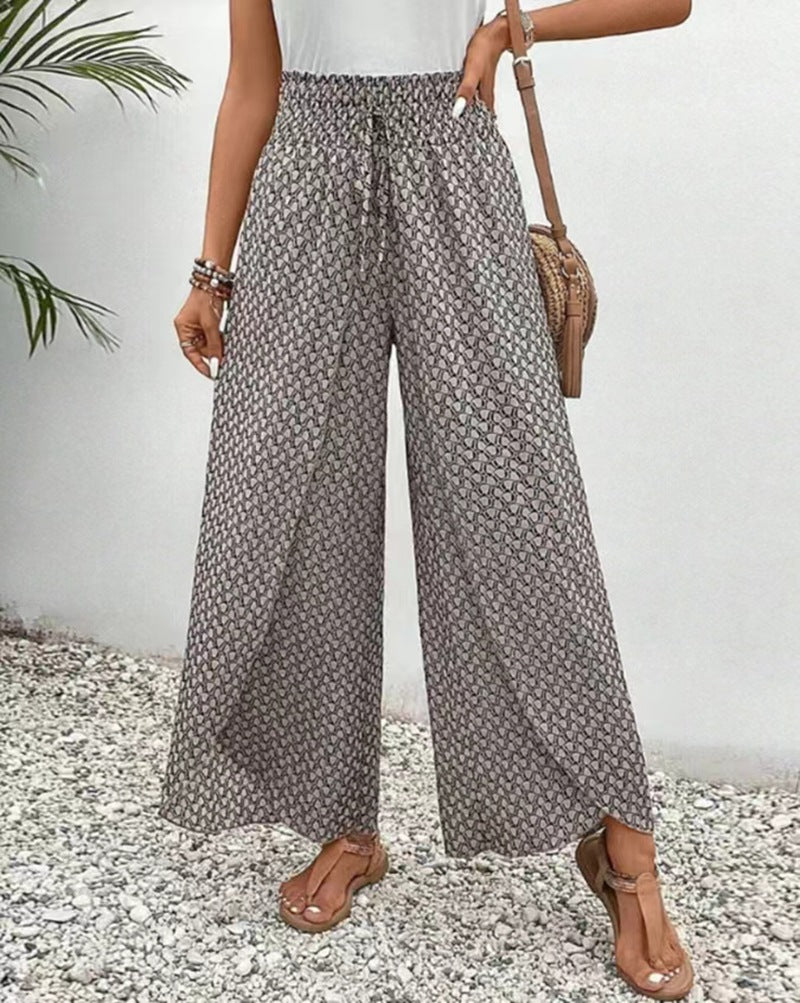 Person wearing patterned wide-leg pants with a white background