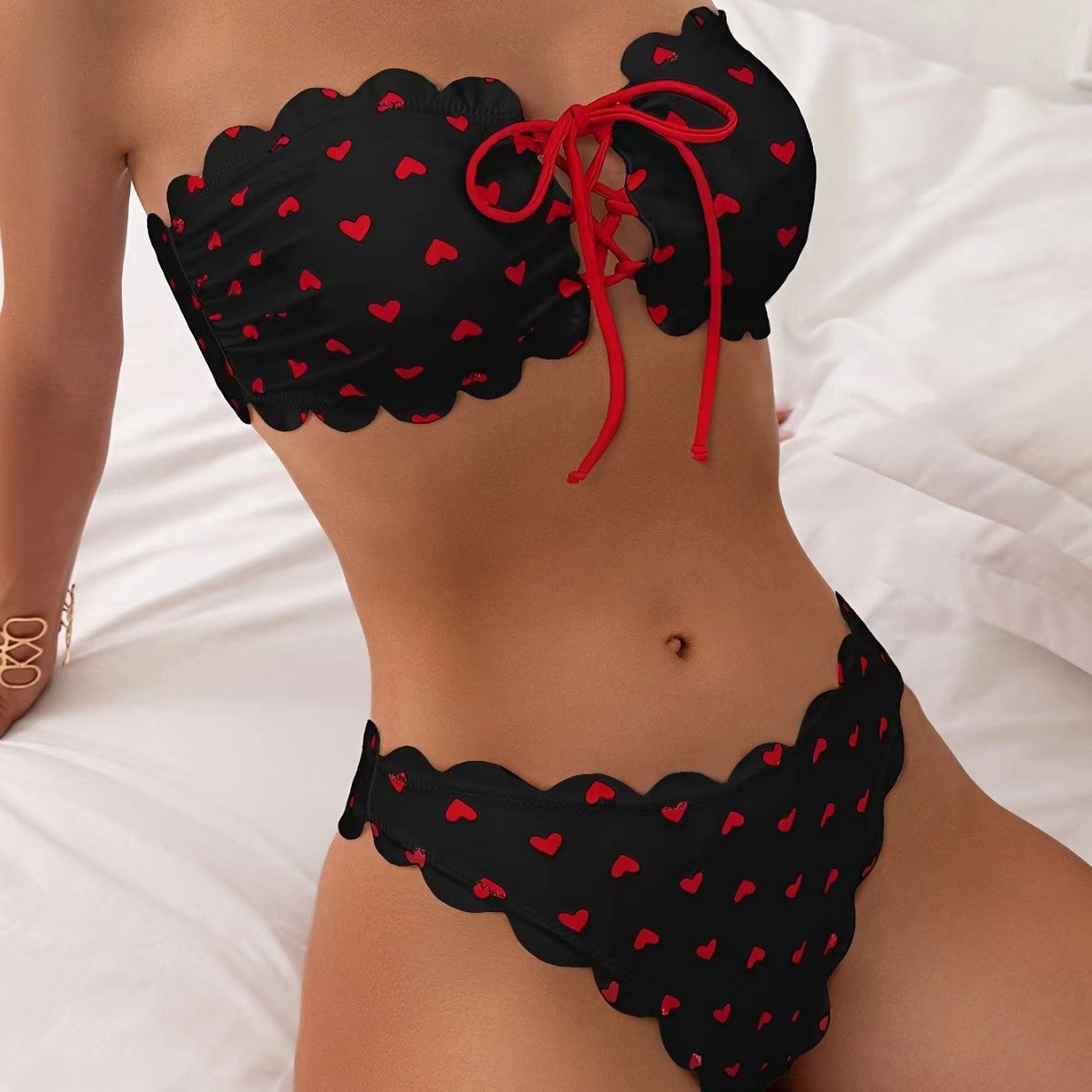 Black bikini with red heart patterns on a white background