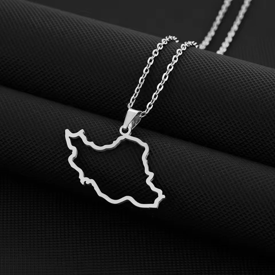 Silver necklace with a map-shaped pendant on a black fabric background