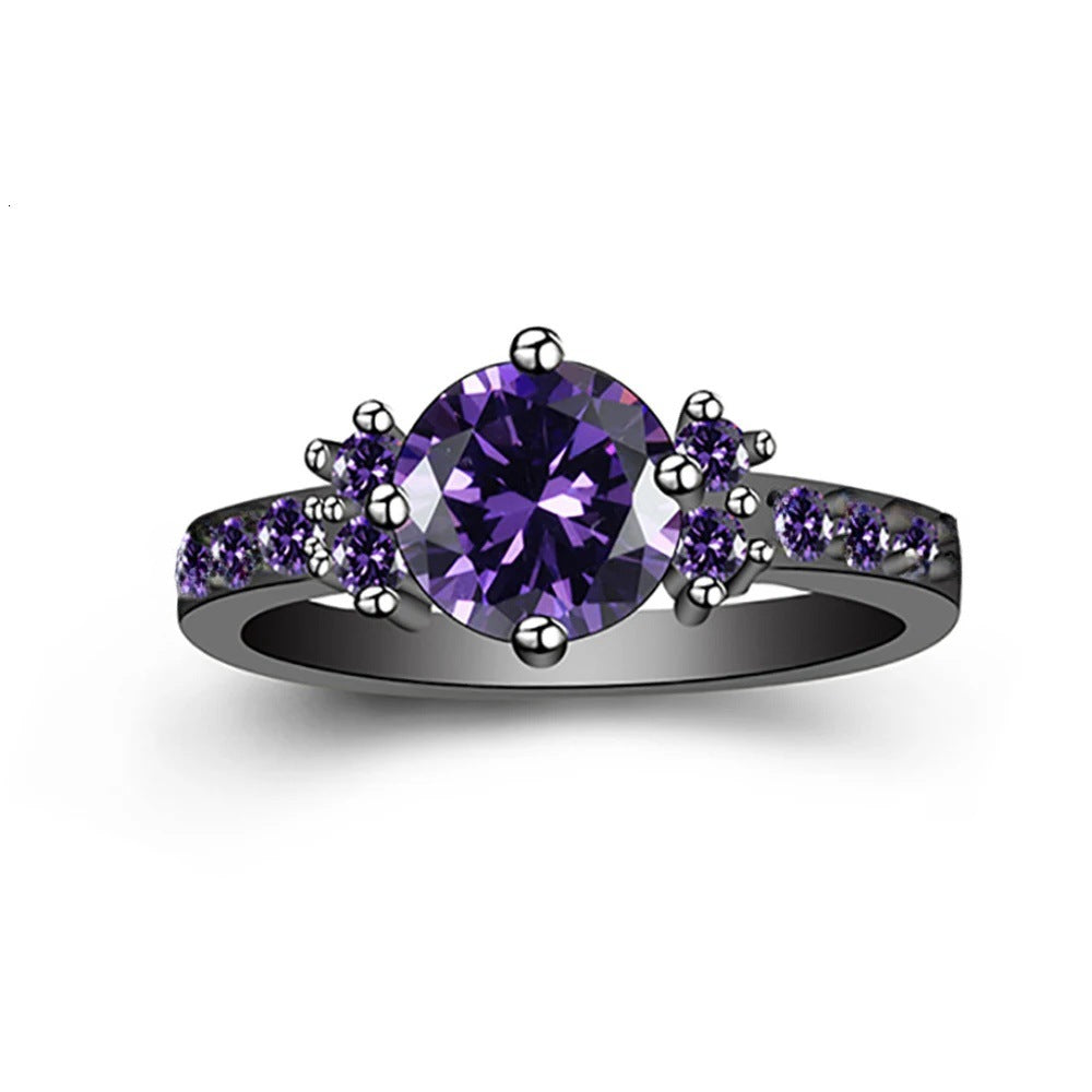 Purple gemstone ring with smaller purple stones on a white background