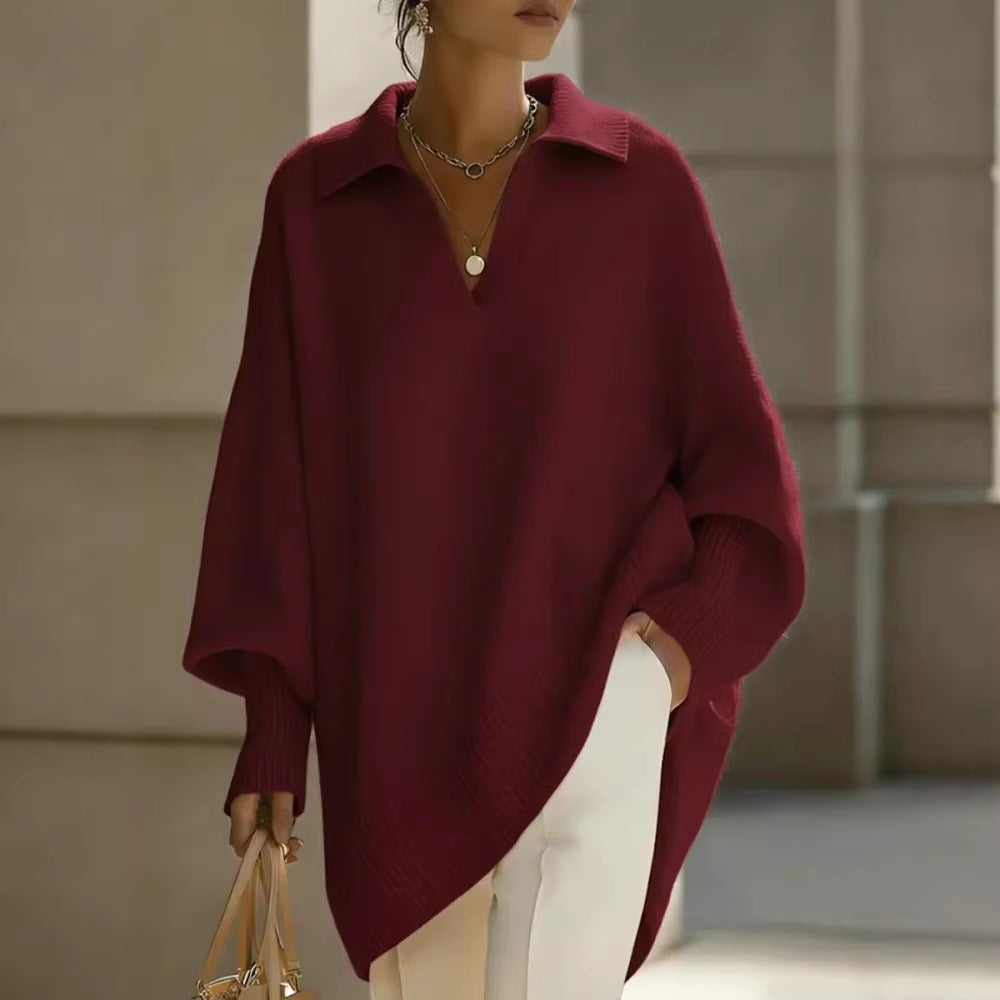Person wearing a burgundy poncho with a neutral background