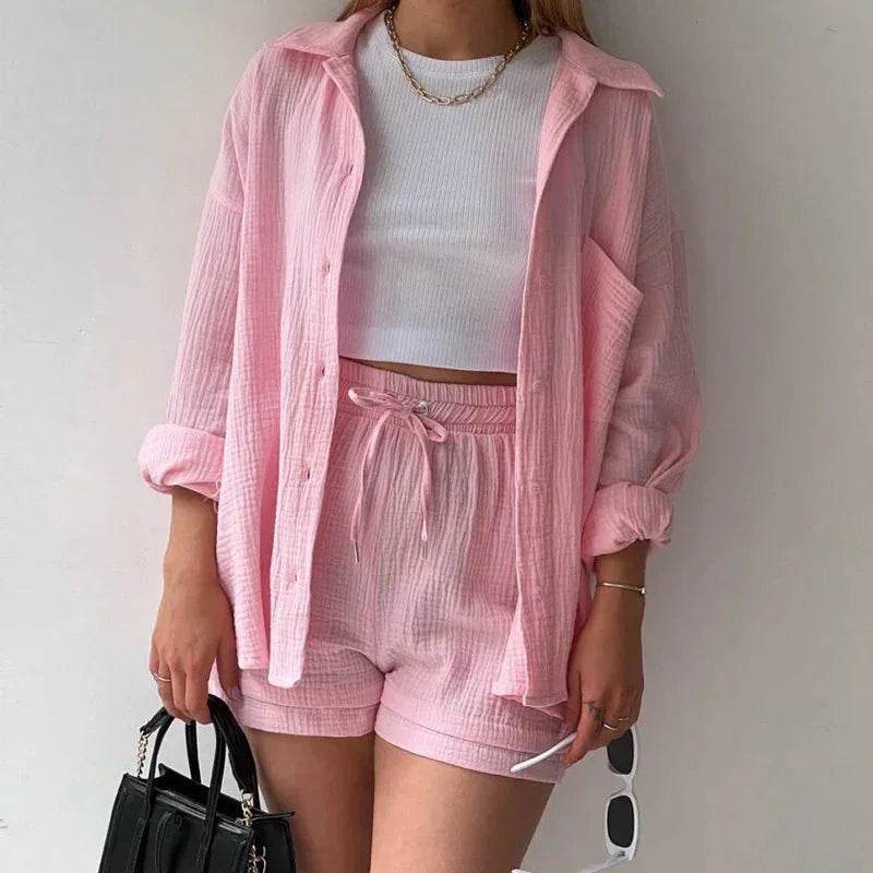 Woman in trendy pink loungewear set and white crop top, holding a black handbag, ZA-Zola fashion