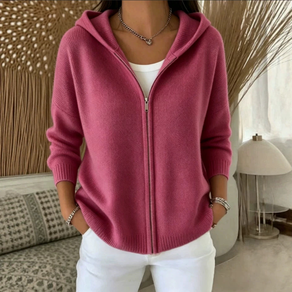 Person wearing a pink zip-up hoodie in a home setting
