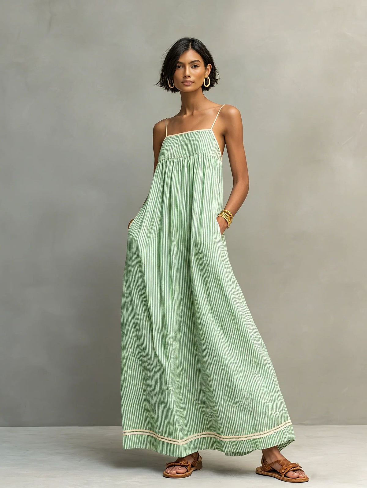 Woman wearing a green striped dress against a gray background