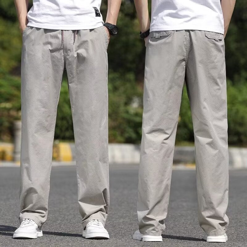 Two pairs of gray pants worn by models on a blurred outdoor background