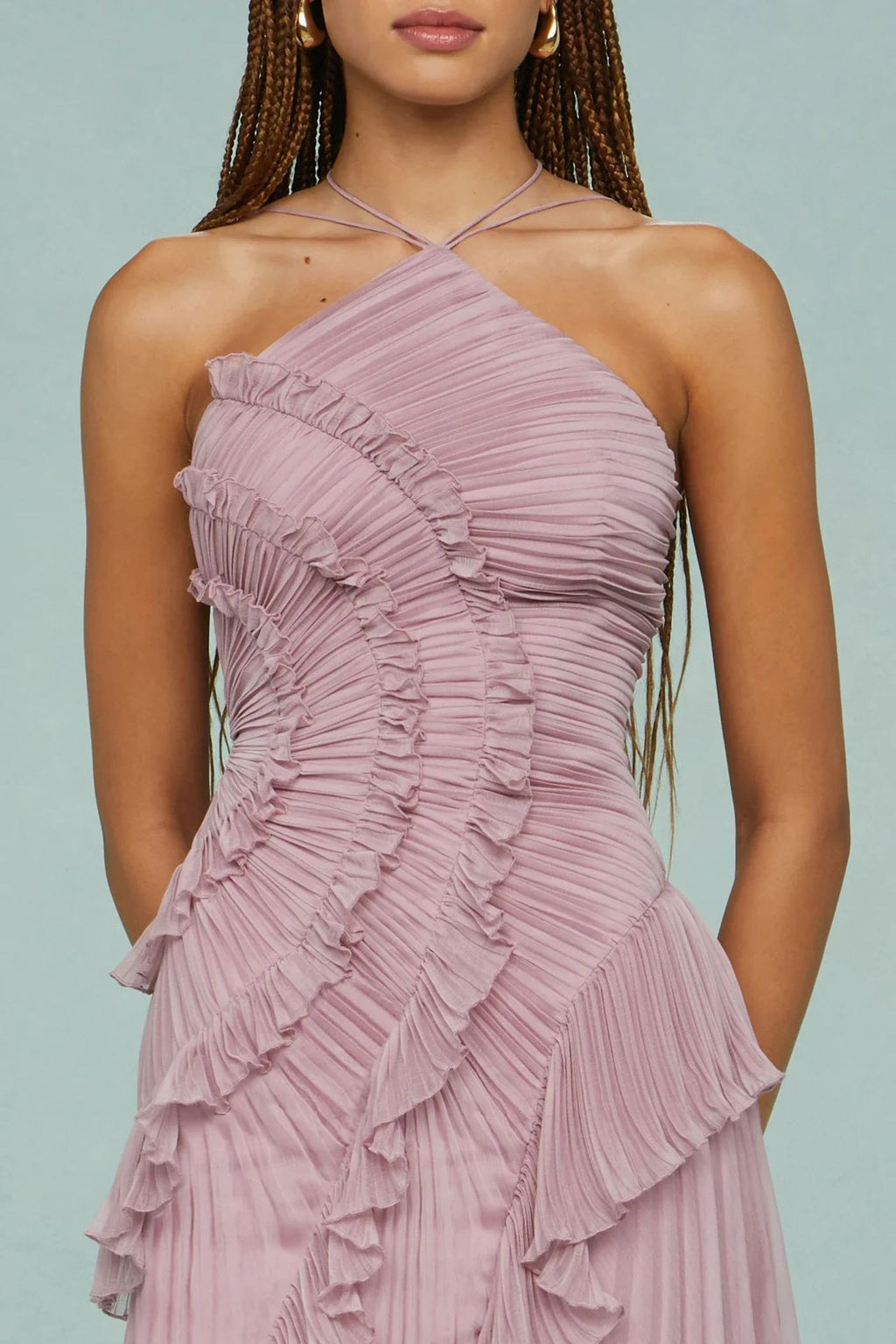 Woman wearing a pink ruffled dress against a light blue background