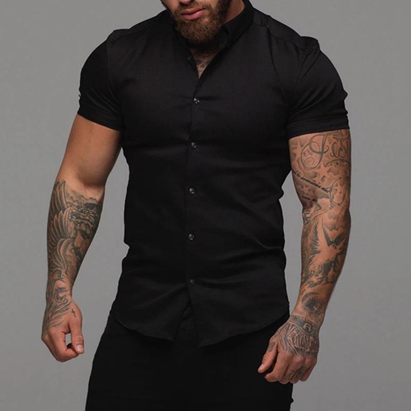 Man wearing a black short-sleeve shirt against a gray background