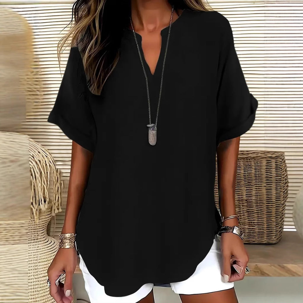 Person wearing a black top and white shorts with a neutral background