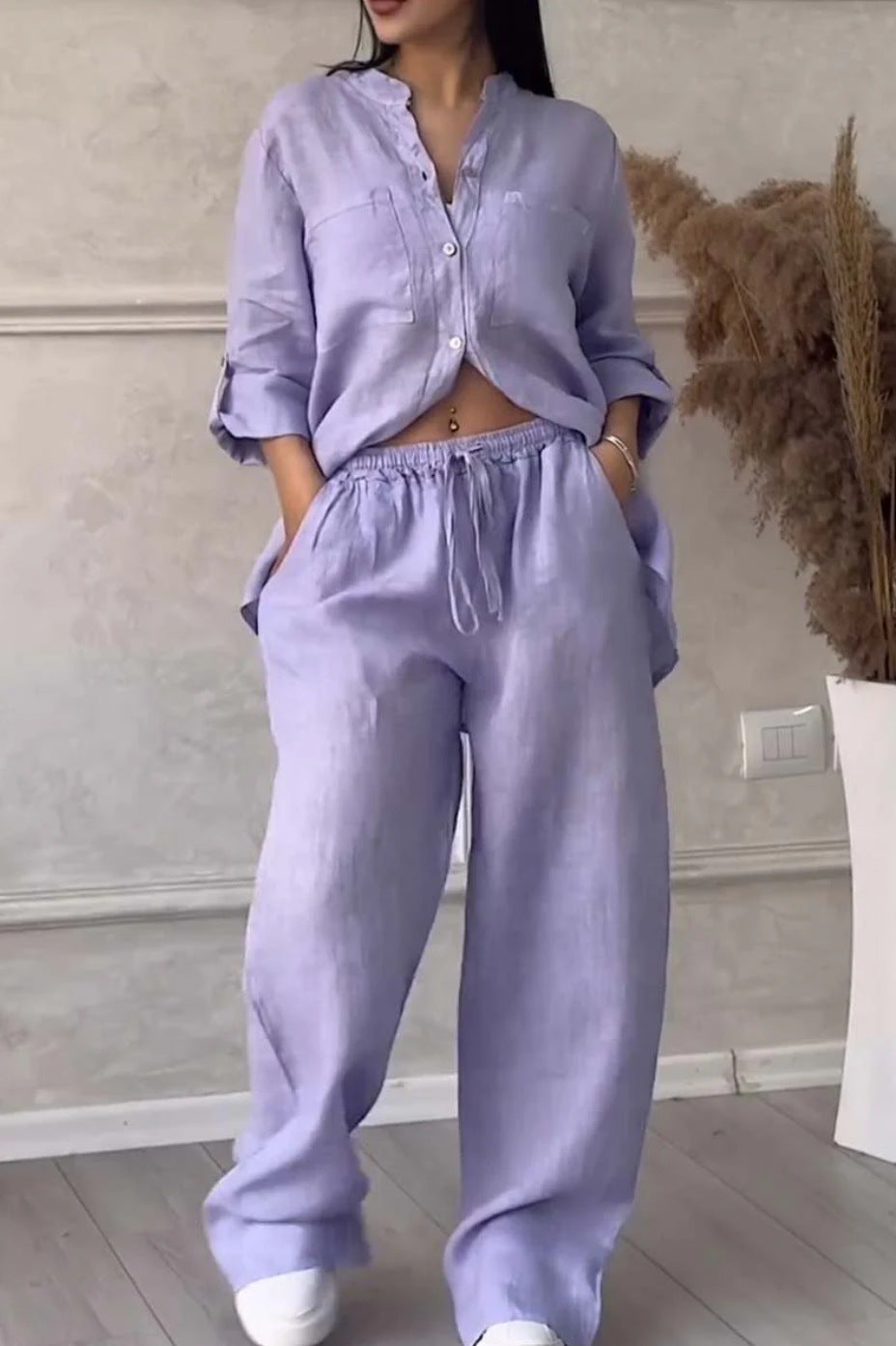 Person wearing a lavender outfit with a neutral background