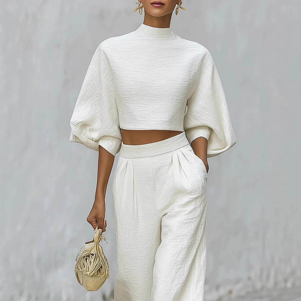 Person wearing a white outfit with a plain background