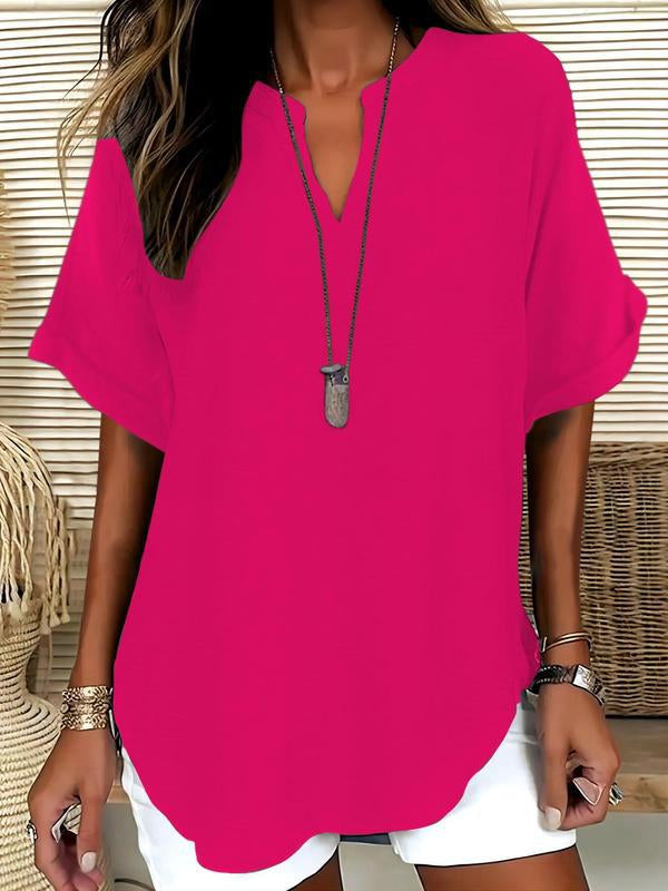 Person wearing a bright pink top with a neutral background