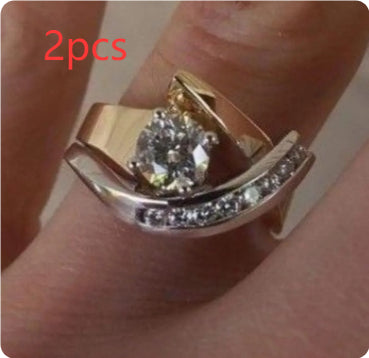 Gold ring with a diamond on a finger, labeled '2pcs'.