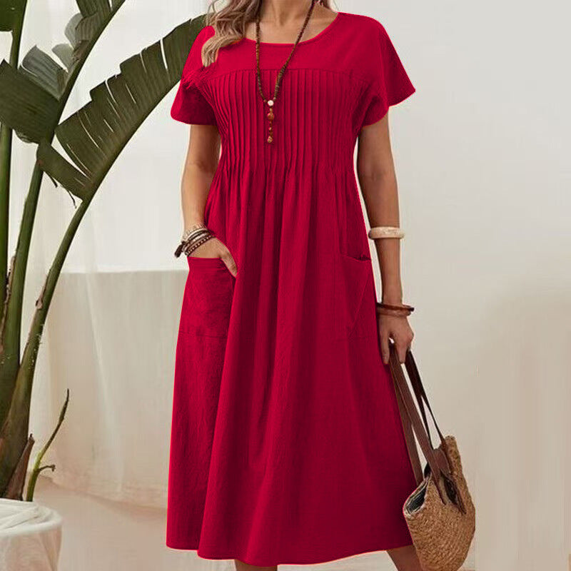 Woman wearing a red dress holding a straw bag indoors.