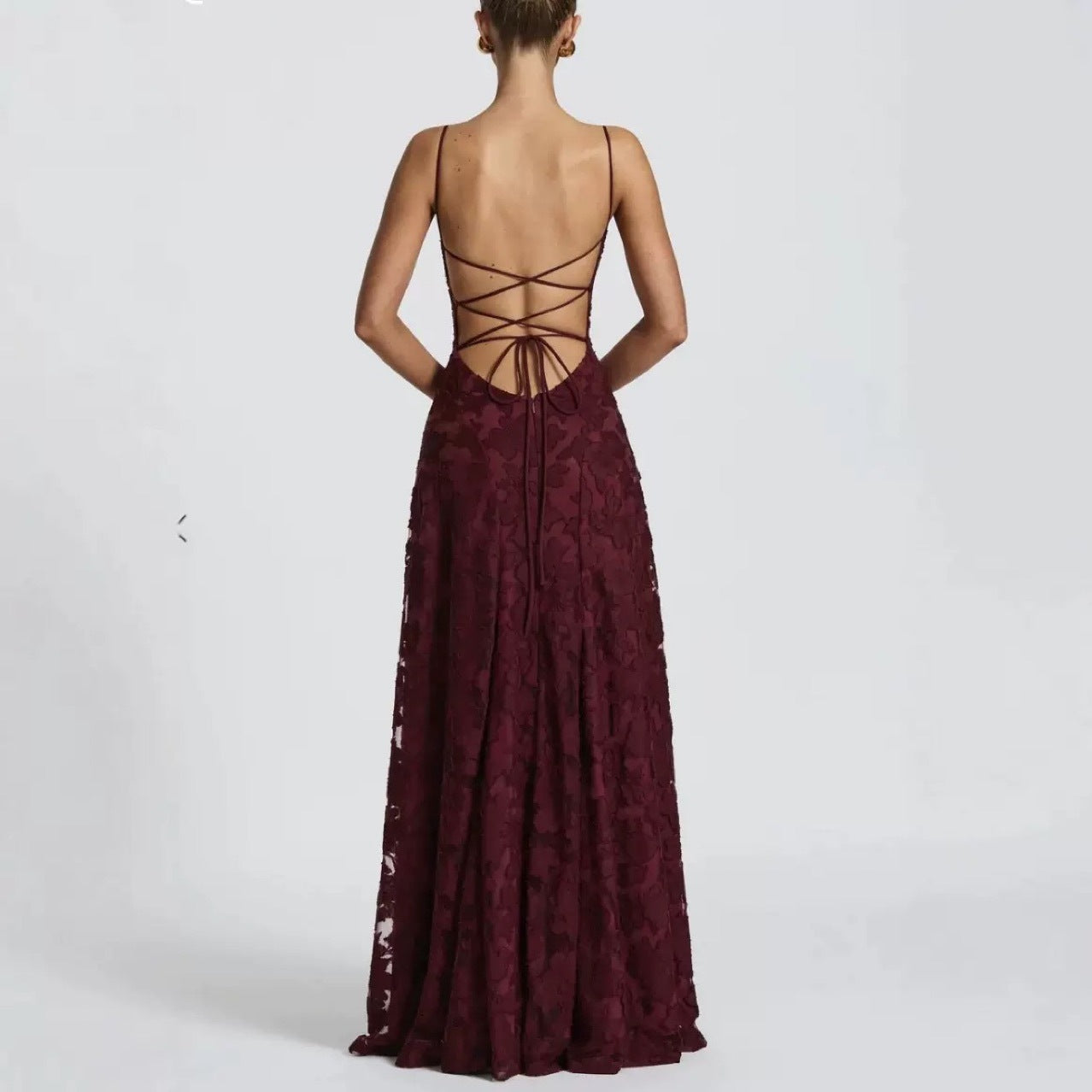 Burgundy lace evening gown with open back on a white background