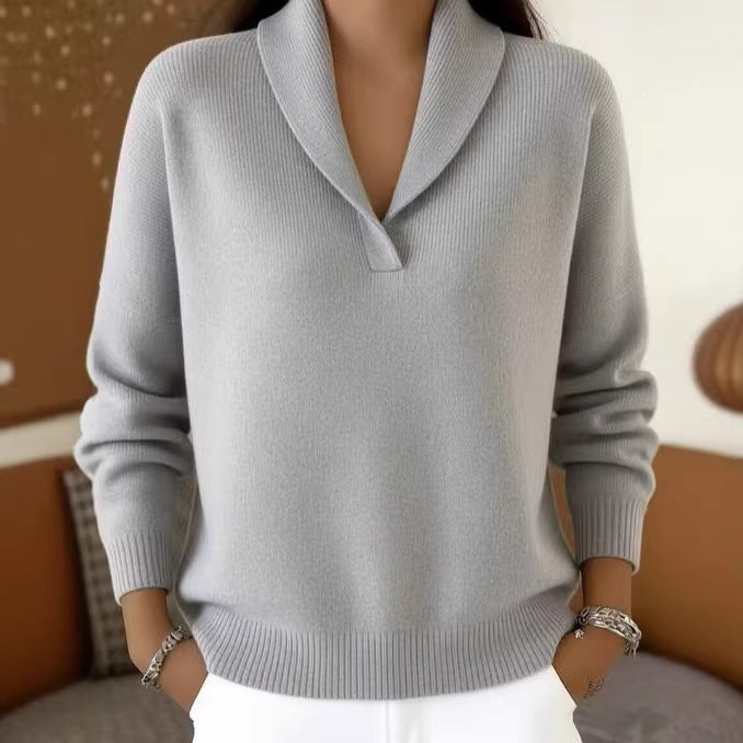 Gray sweater worn by a person with a blurred background