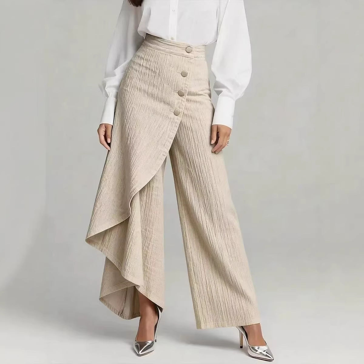 Person wearing beige pleated pants and a white shirt on a light gray background