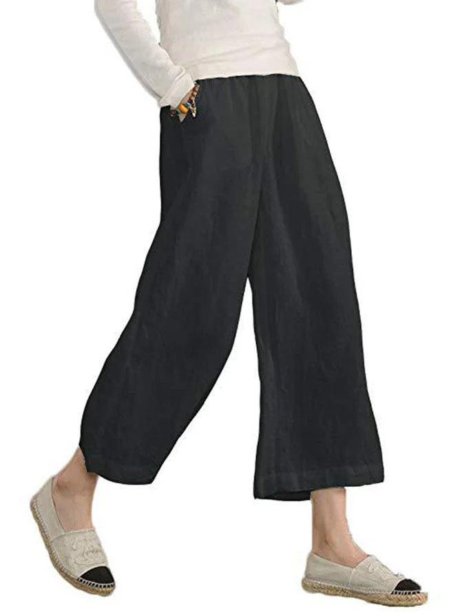 Person wearing black wide-leg pants on a white background