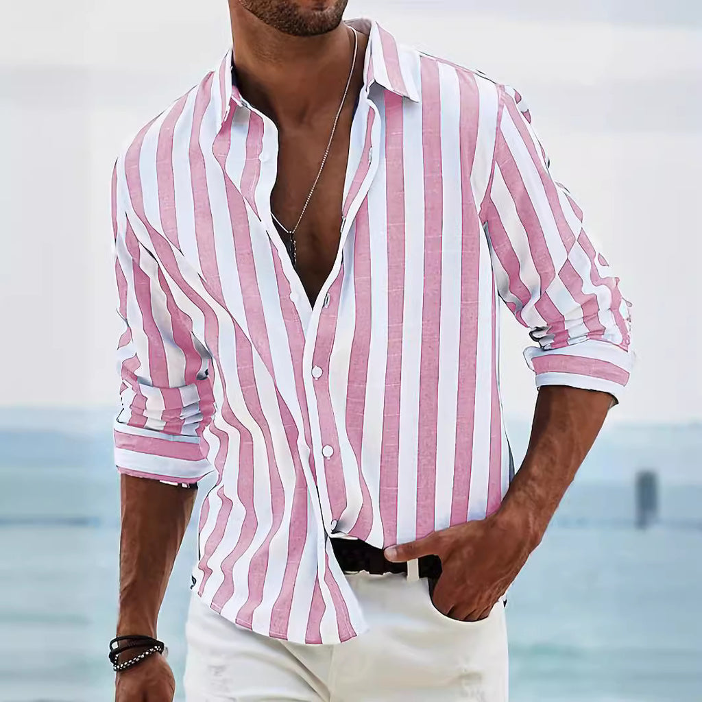 Man wearing a pink and white striped shirt with a blurred beach background
