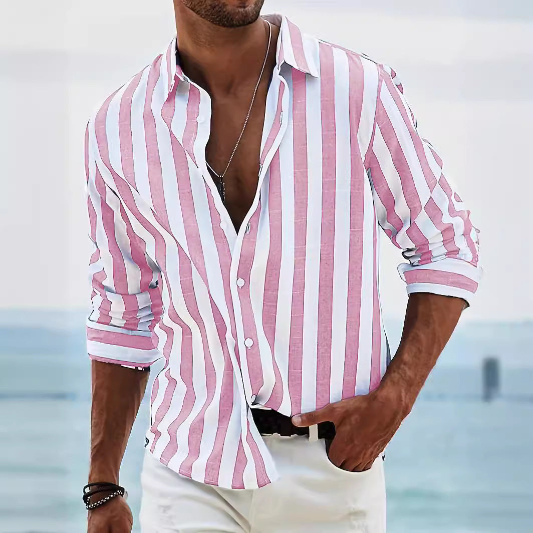 Man wearing a pink and white striped shirt with a blurred beach background