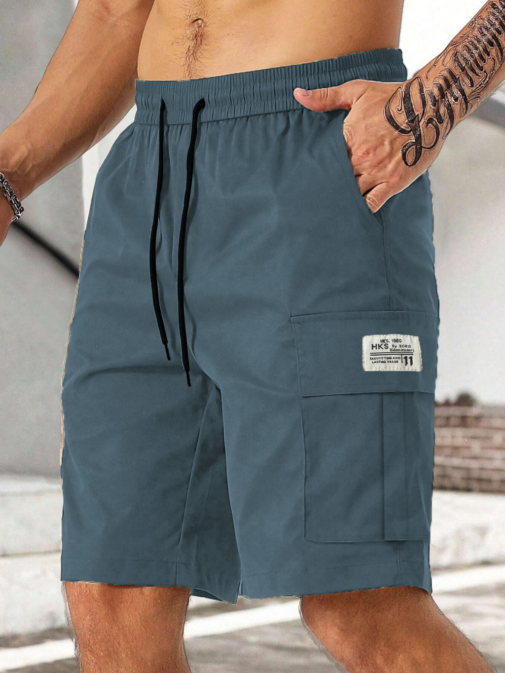 Blue shorts with a drawstring and pocket on a neutral background