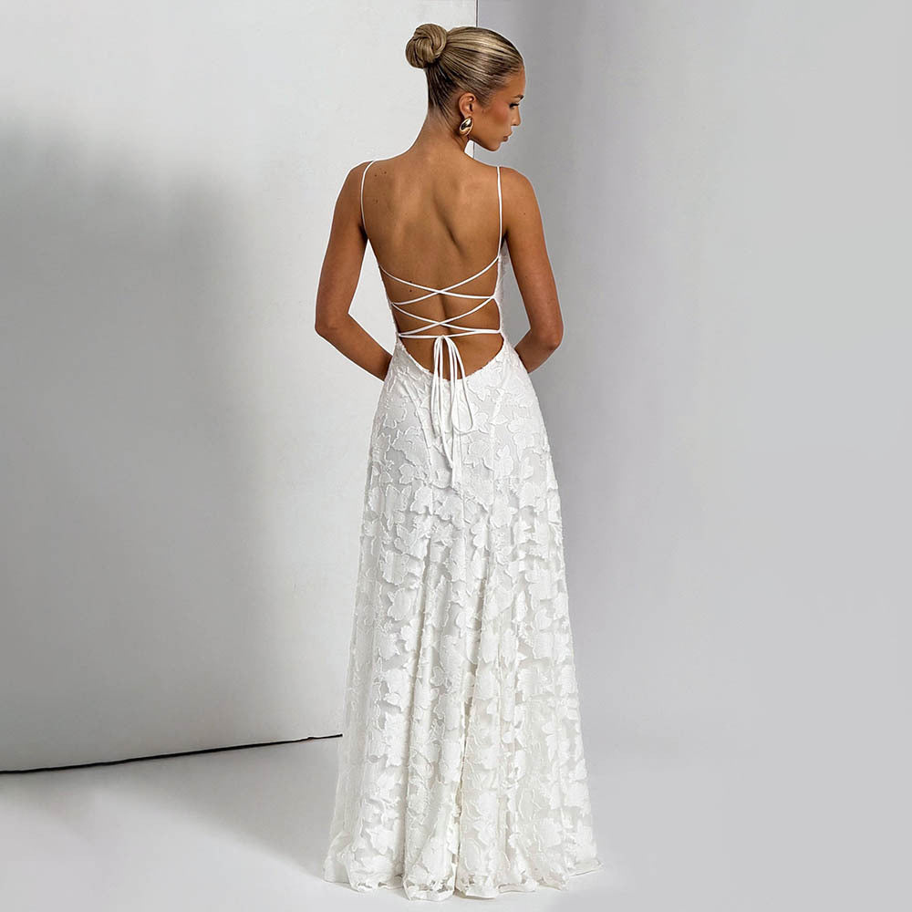 Woman wearing a white lace dress with an open back against a plain background