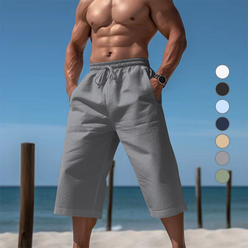 Man wearing gray shorts on a beach with color swatches.