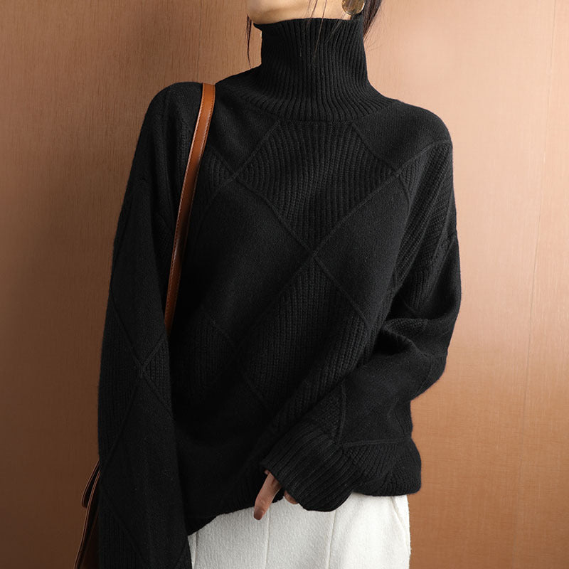 Person wearing a black turtleneck sweater against a brown background