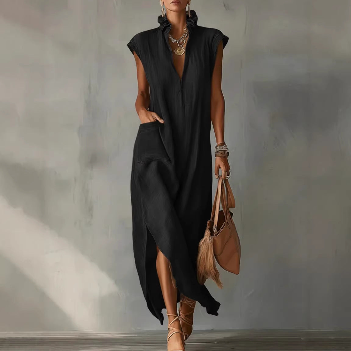 Woman wearing a black sleeveless dress with a plain background